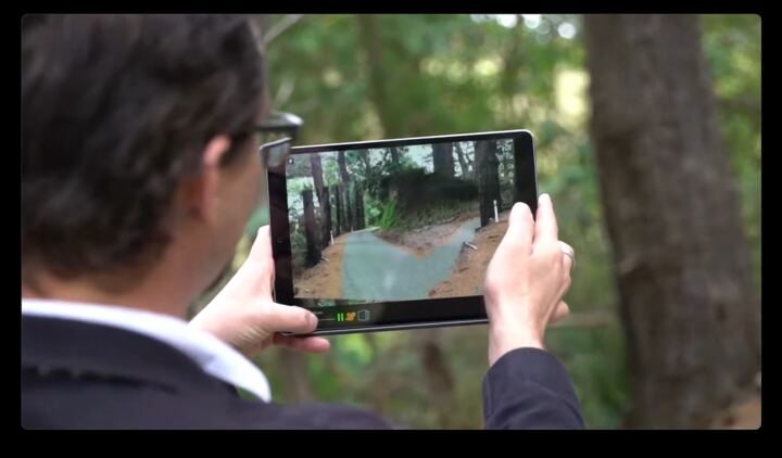 Man holding an iPad running Flotogram on a forest path