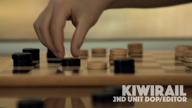 Hand moving a checkers piece from a KiwiRail commercial