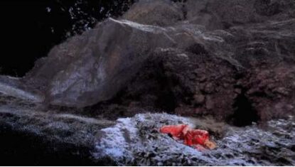 Mia in red lying in a snowy point-cloud landscape